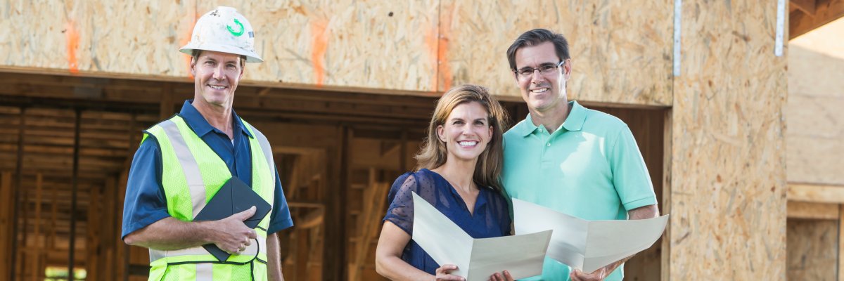 Builder and couple at new home under construction